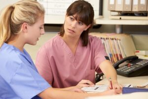 Two nurses working at nurses station