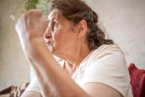 Portrait of an angry old woman showing fist