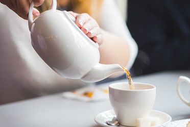 Side view of a female pouring tea